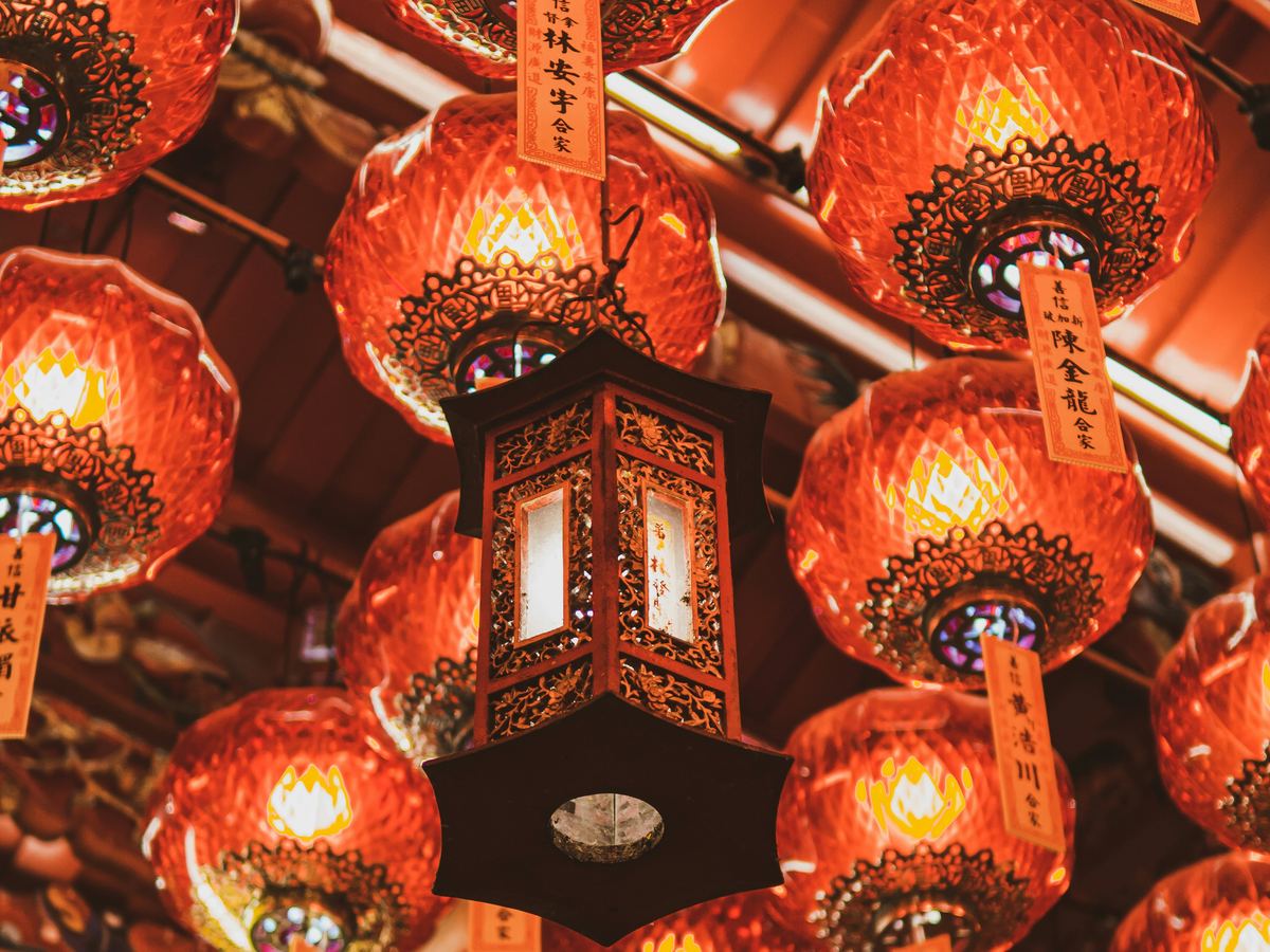 Red and gold lanterns hanging from a temple ceiling